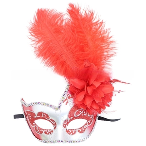 Dettaglio di piume rosse e fiore di seta su maschera in argento per feste di gala