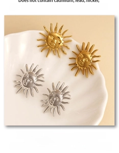 Detailed view of nickel-free stainless steel sun face earrings in gold and silver finish