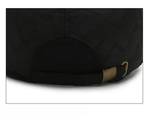 Detail of adjustable metal buckle and quilted fabric texture on back of winter cap