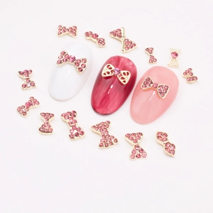 Golden bow nail charms with pink rhinestones shown on various festive base colors