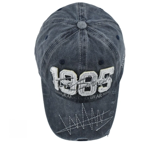 Macro shot of 1985 embroidery and distressed details on washed cotton baseball cap