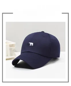 Detail of dark blue canvas baseball cap with white polar bear embroidery and vent holes