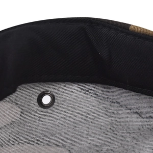 Macro shot of cotton camouflage baseball cap interior featuring metal eyelet and sweatband