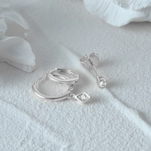 Detailed view of silver 925 huggie hoop earrings with square cubic zirconia charms