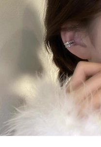 Detail shot of a silver double-layered zircon ear cuff worn on the earlobe