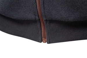 Detail of premium ribbed hem and high-quality brown metal zipper on black hoodie