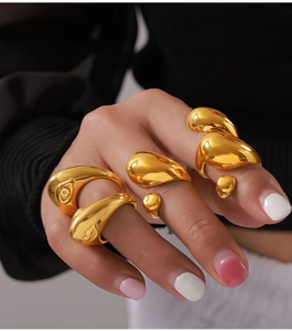 Detailed view of three fluid gold rings with unique organic textures and high polish finish