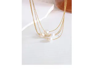 Close-up of elegant multi-layer gold chain necklace with four white freshwater pearls