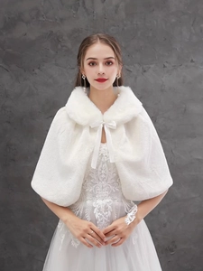 Detail of white faux fur bridal shawl featuring a delicate front ribbon bow tie