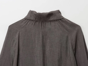 Detail of dark taupe bomber jacket fabric with a slight sheen and fine woven texture