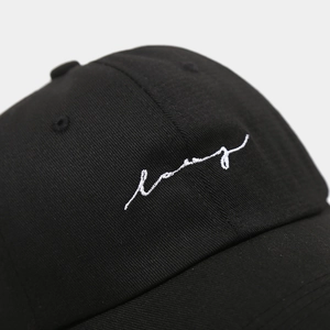 Close-up of premium white script embroidery on a black cotton twill baseball cap fabric