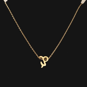 Detailed view of a gold zodiac pendant necklace on a sleek black background