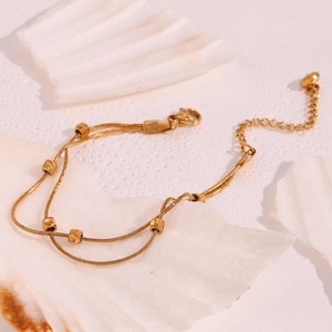 Detail view of 18K gold plated double layer snake chain bracelet with square beads