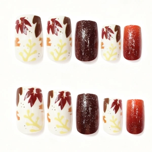 Autumn maple leaf press-on nails with red glitter gradients and orange sparkles