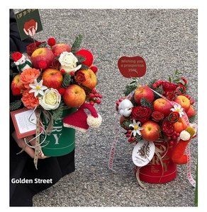 Close-up of a Christmas floral bucket gift set with red roses, apples and cotton decor