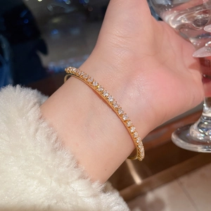 Close-up of 18K gold plated tennis bracelet with sparkling zircons on a woman's wrist