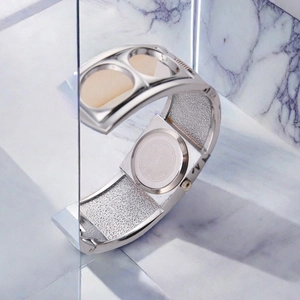 Detail of silver bangle watch showing the stainless steel back on white marble