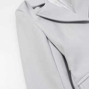 Dettaglio del rever di un cappotto in lana grigio chiaro con trama del tessuto di qualità