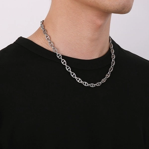 Detailed view of silver stainless steel pig nose anchor chain worn by a male model