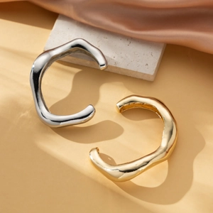 Chunky irregular wavy open bangles in 18k gold and silver stainless steel finish