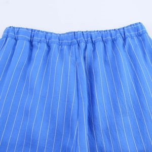 Detail of blue striped trousers with an elastic waistband and fine fabric texture