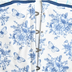 Close-up of floral corset top with blue butterfly print and metal hook-and-eye closure
