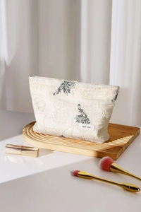 Close-up of botanical embroidery and floral relief texture on linen makeup bag