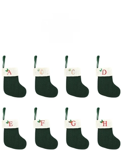 Vue détaillée de mini chaussettes de Noël en tricot vert avec lettres brodées rouges A à H