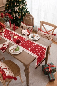 Detailed knit texture of red Christmas table runner with white reindeer and snowflake motifs