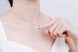 Close-up of a twisted S925 sterling silver pendant necklace with a sparkling gemstone