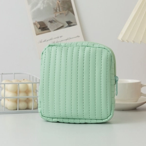 Detail of mint green quilted leather cosmetic pouch with zipper and vertical stitching