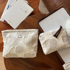 Detail of cotton linen cosmetic bags with jacquard polka dots and tassel zipper on wood