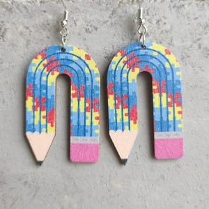 Detail of wooden pencil earrings with colorful puzzle pattern and vibrant painted eraser tip