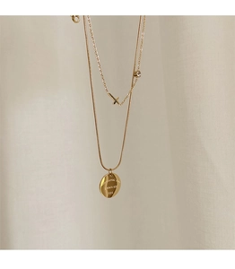 Detail of 18K gold plated double layer necklace with cross and engraved love pendant