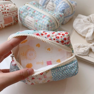 Macro detail of quilted cotton makeup bag with floral patterns and zipper closure