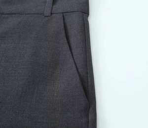 Gros plan détaillé sur la texture du tissu gris foncé et la poche latérale du short
