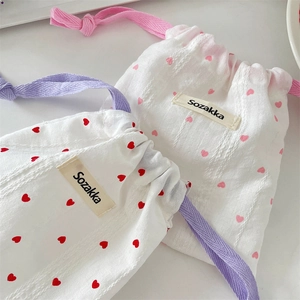 Dettaglio di sacchetti in cotone con coulisse e motivi a cuori rossi e rosa