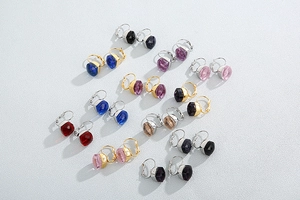 Flat lay of multiple colorful faceted crystal glass earrings in gold and silver finish
