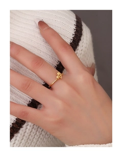 Detailed view of a gold-plated coconut tree ring on finger with soft knit background