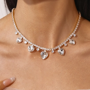 Macro detail of luxury heart fringe necklace with gold tennis chain and zircon stones
