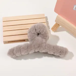 Detail view of large dark grey plush hair claw clip with soft faux fur texture for winter