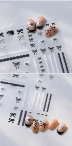 Detailed view of black and white bow nail stickers with sweet lace and heart patterns