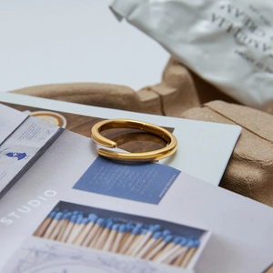Polished 18K gold-plated stainless steel open ring displayed on an aesthetic background