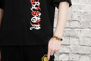 Close-up of men's black leather bracelet with golden skull on model's wrist