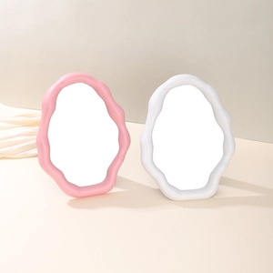 Pink and white cloud shaped wavy vanity mirrors on beige minimalist desk setup