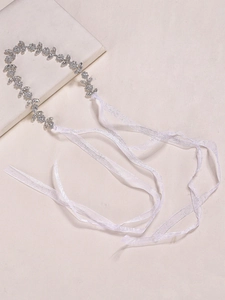 Détail d'un serre-tête de mariée en strass argenté avec des rubans de soie blancs soyeux