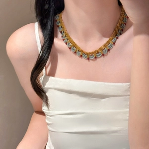 Détail du collier ras du cou en dentelle de perles dorées et perles de cristal bleues
