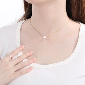 Elegant gold titanium steel necklace with pearl pendant and matching pearl ring on model