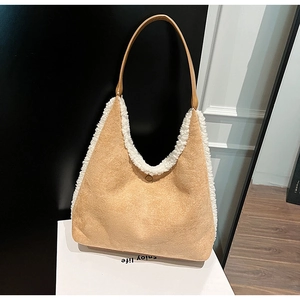 Detail view of tan suede tote bag with thick white sherpa fleece trim and magnetic closure