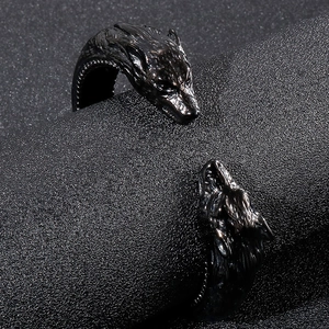 Gros plan d'un bracelet ouvert tête de dragon en acier noir avec gravures détaillées